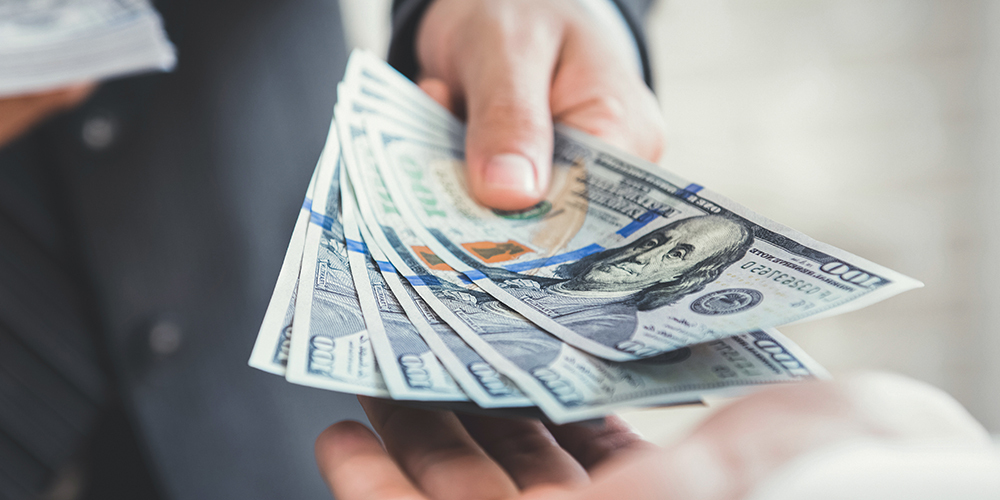 one person handing a large amount of cash to another