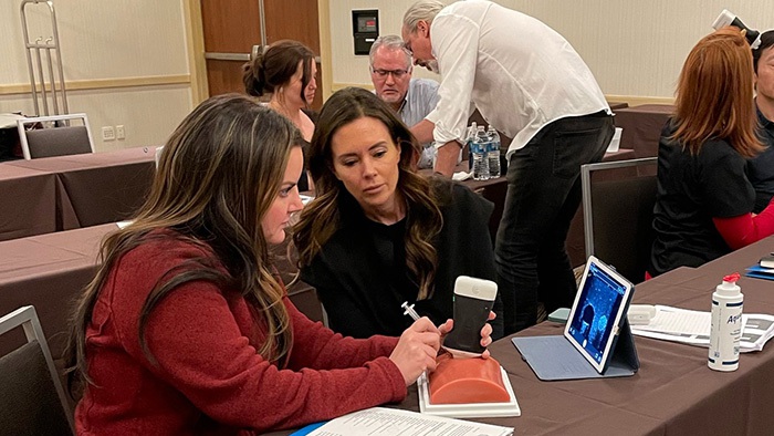 Med spa injectors practice using ultrasound tech during an Ultrasound Fundamentals course with Dr. Steven Weiner.